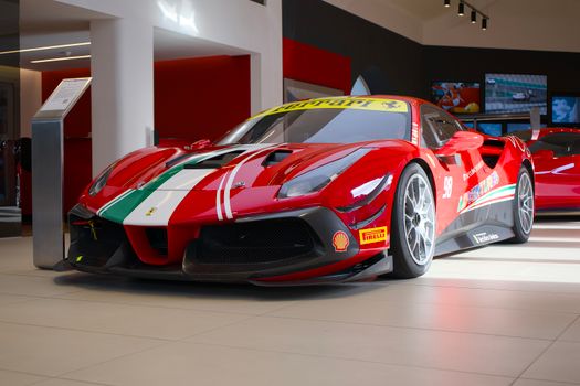 Showroom display of a red Ferrari sports car with racing decals and vibrant design.