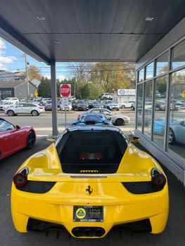 A vibrant yellow Ferrari 458 waits at a New Jersey dealership, ready to impress.